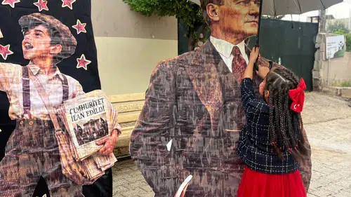 Yağmura aldırış etmedi: Atatürk'e şemsiye tutan küçük kız yürekleri ısıttı